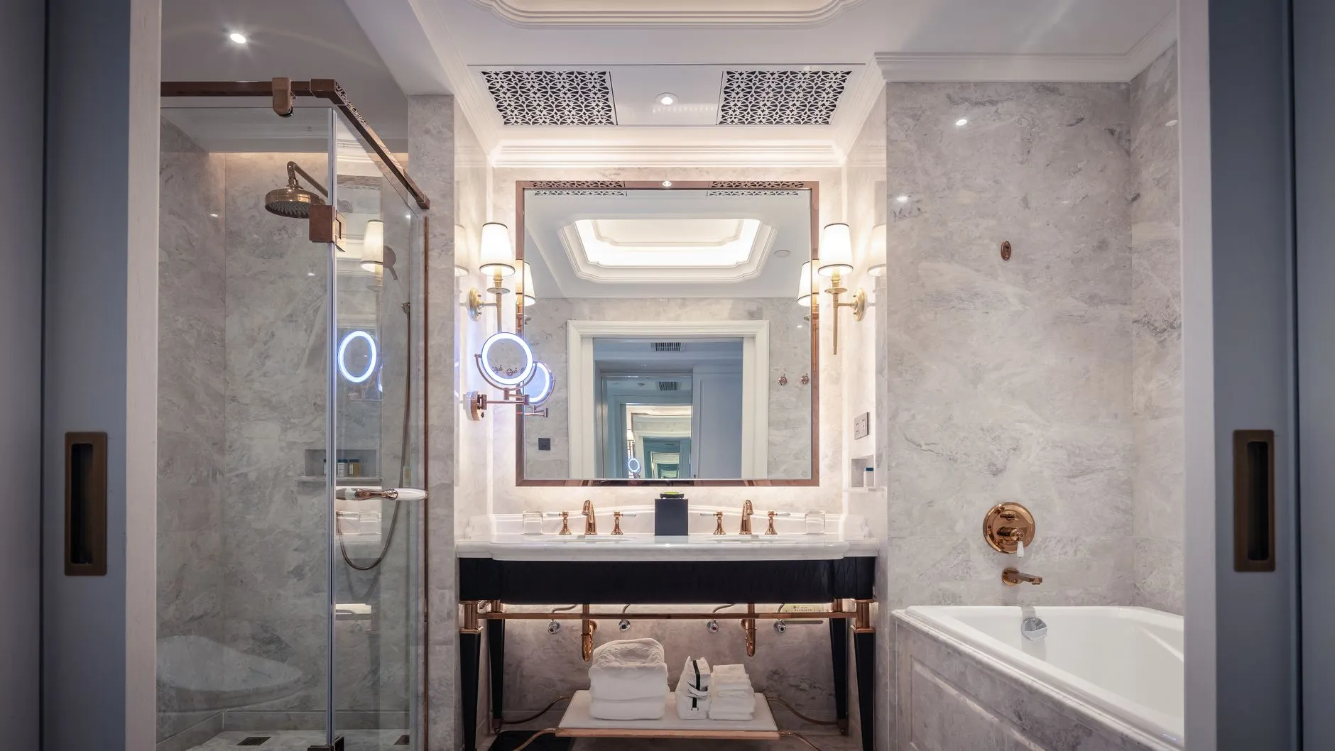 Elegancka hotelowa łazienka z marmurowymi ścianami, wanną i prysznicem