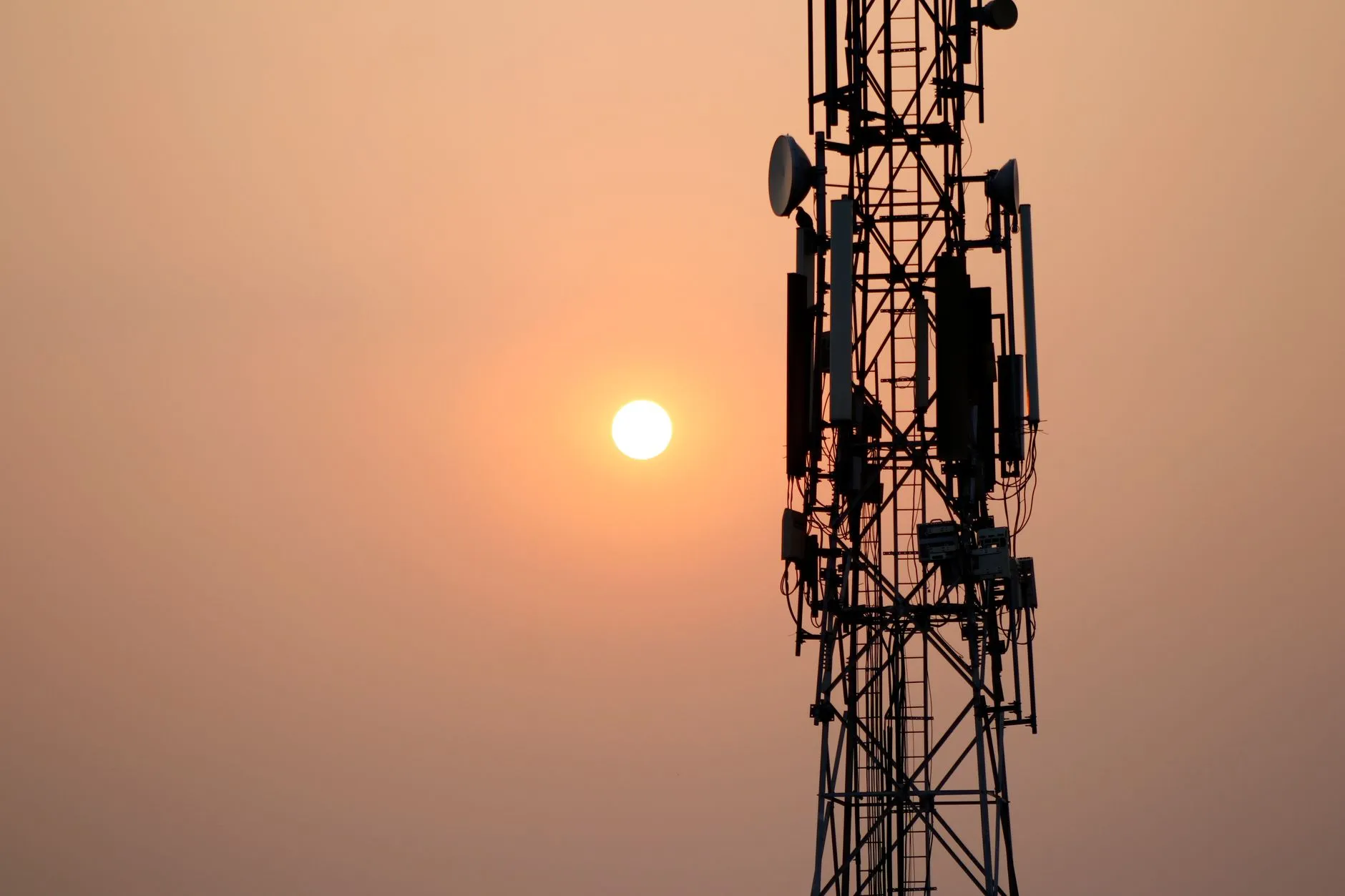 Wieża telekomunikacyjna na tle zachodzącego słońca